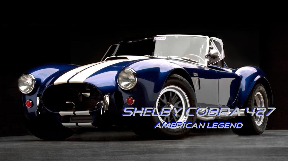 Front view of a dark blue classic Shelby Cobra 427 with white racing stripes in a studio setting.