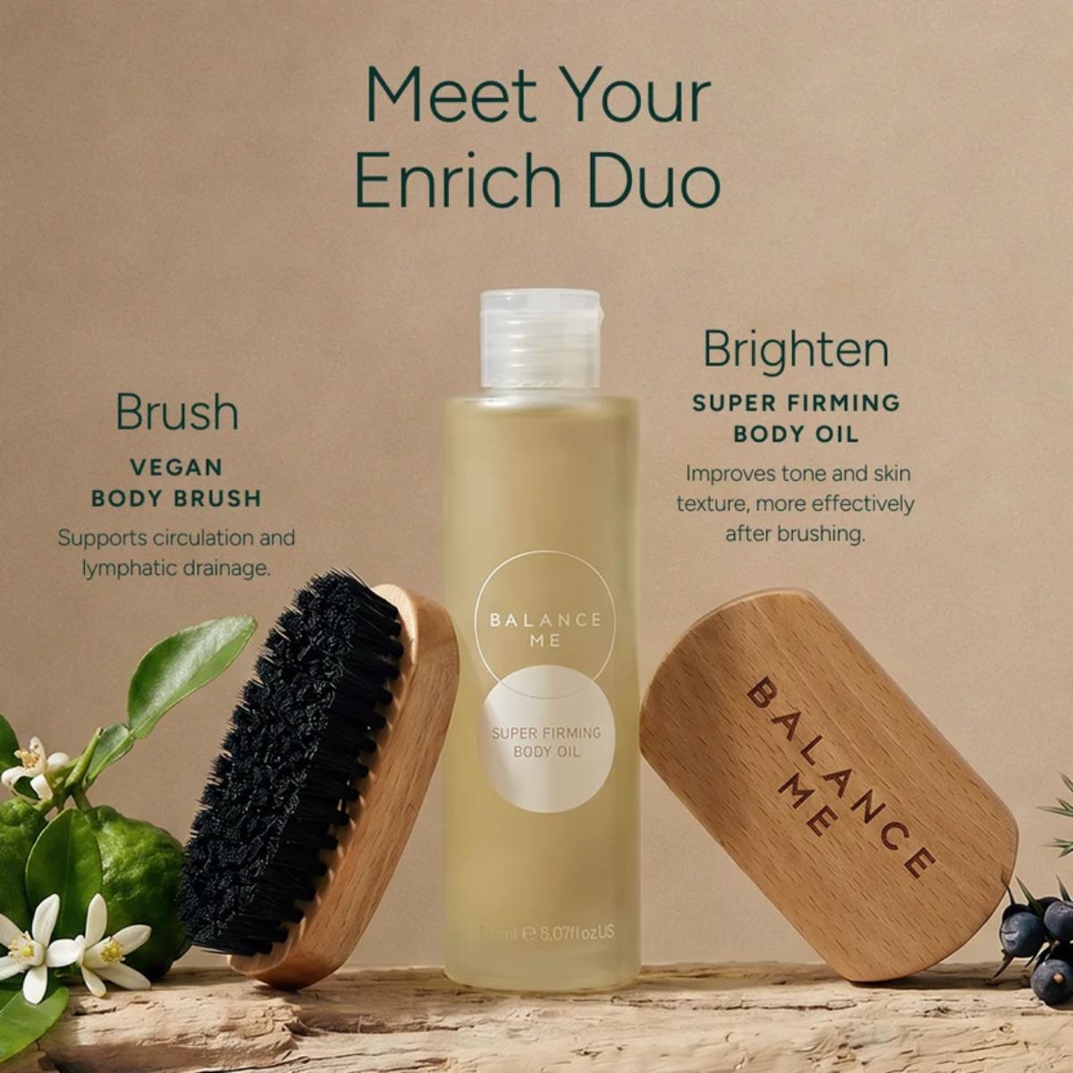 Balance Me Brush and Brighten duo featuring vegan body brushes and Super Firming Body Oil on a rustic wooden surface with botanicals