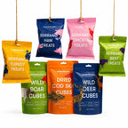 Buddylicious Training Treats Bundle with seven varieties of natural dog training treats including Serrano meats, wild deer, wild boar and cod skin cubes