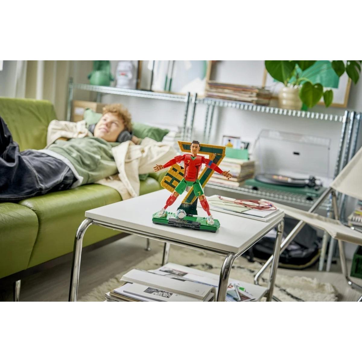 Living room with a person lying on a couch and a superhero figurine on a table.