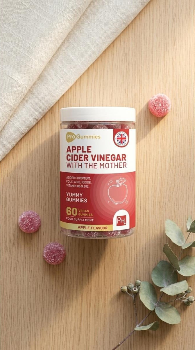 Jar of prowise apple cider vinegar gummies on a wooden surface with pink gummies around
