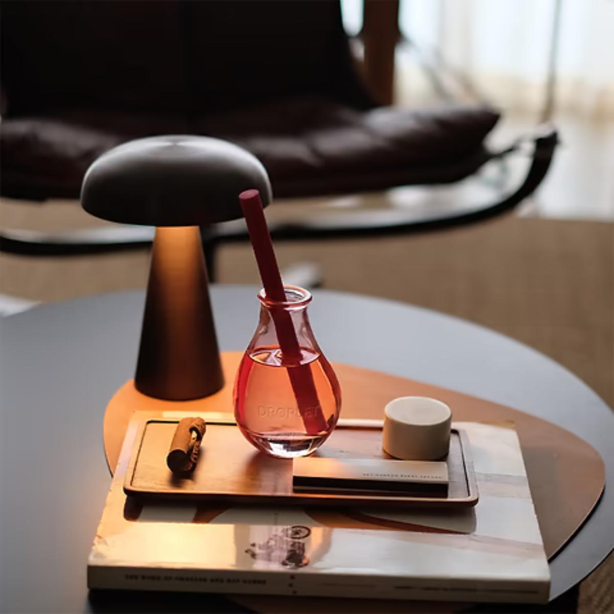 Table with a lamp, vase, mug, and book in a modern interior setting