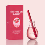 Pink perfume bottle with packaging labeled 'Meet Me on Sunset' on a light pink background