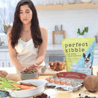 Woman preparing food in a kitchen with 'Perfect Kibble' packaging visible