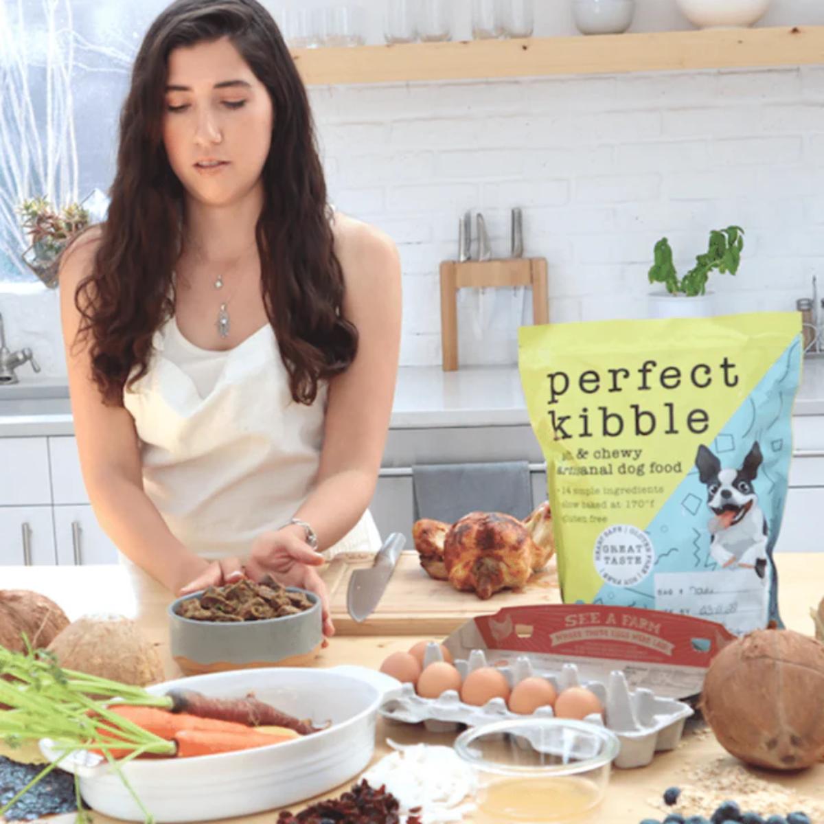Woman preparing food in a kitchen with 'Perfect Kibble' packaging visible